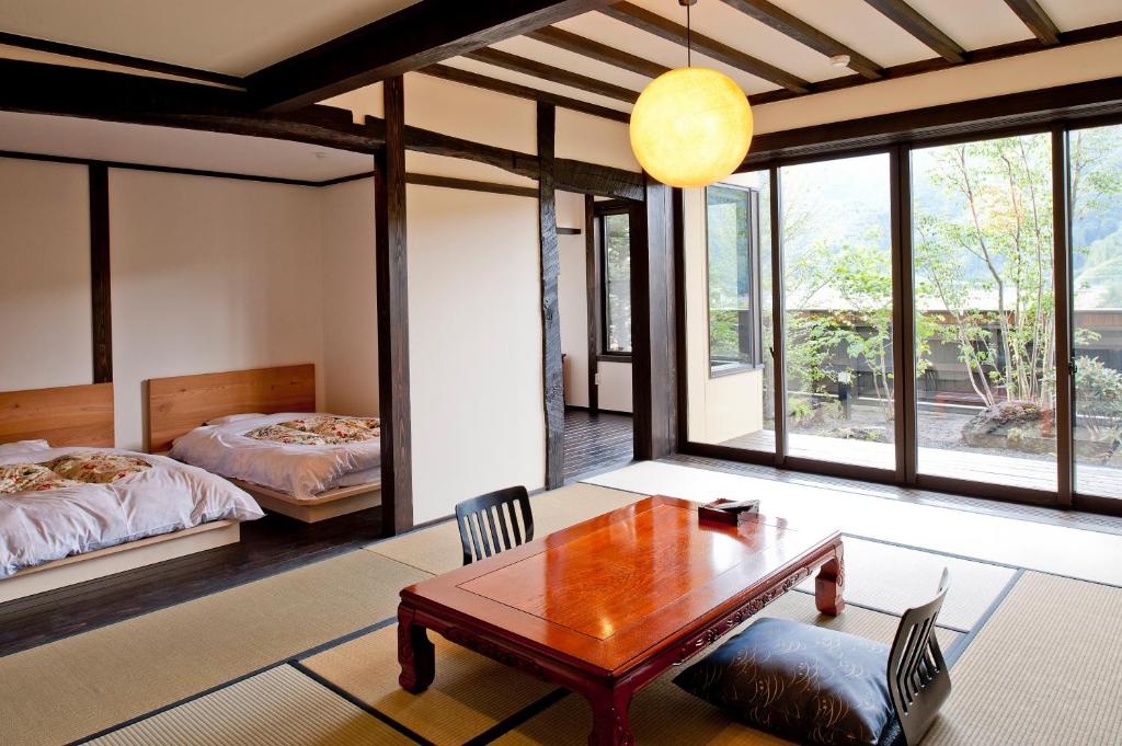 un salon avec une table et un lit dans l'établissement Yamakikan, à Naganohara 147 autres photos