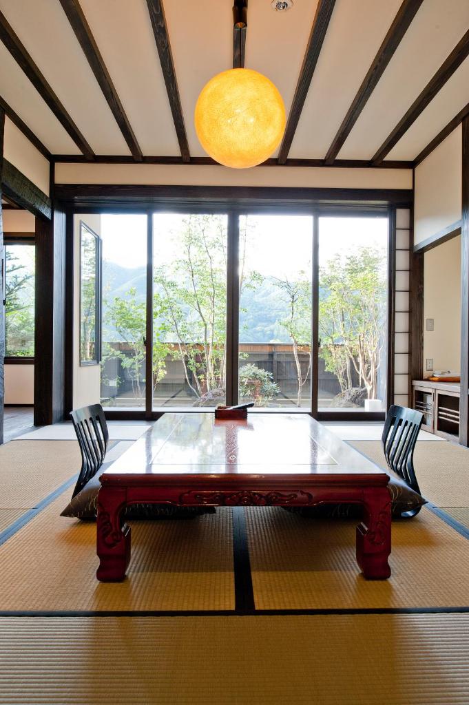 une salle à manger avec une table et une grande fenêtre dans l'établissement Yamakikan, à Naganohara