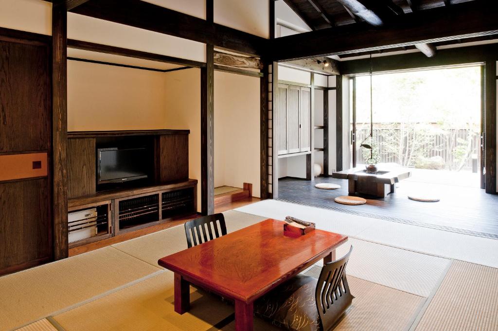 un salon avec une table et une télévision dans l'établissement Yamakikan, à Naganohara