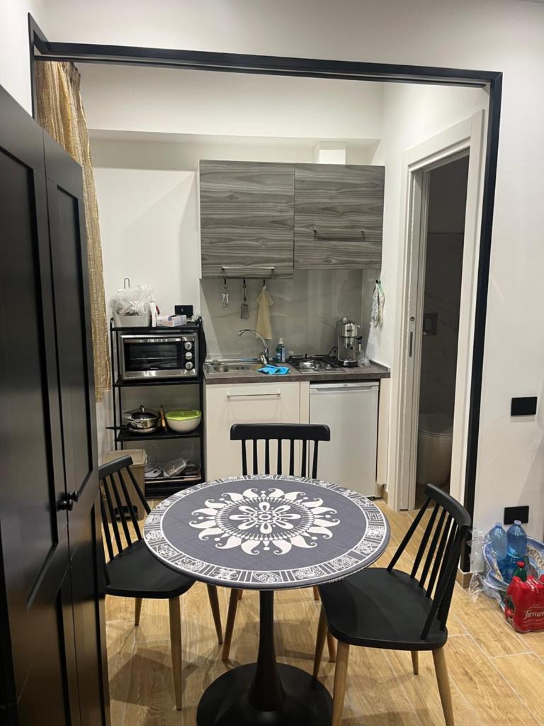 une cuisine avec une table et des chaises dans une cuisine dans l'établissement Residenza Cristforo Colombo, à Crotone