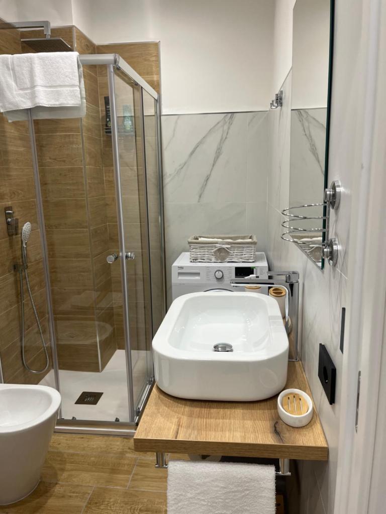 une salle de bain avec un lavabo blanc et une douche dans l'établissement Residenza Cristforo Colombo, à Crotone