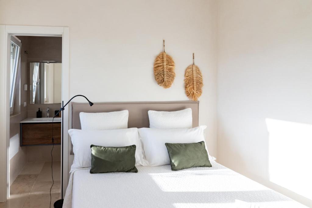 - une chambre avec un lit blanc et 2 oreillers verts dans l'établissement Bianca Balistris, à Polignano a Mare