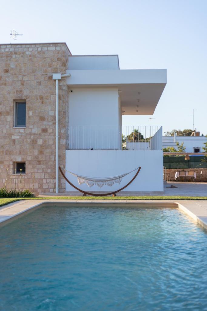 - un hamac dans une piscine en face d'une maison dans l'établissement Bianca Balistris, à Polignano a Mare
