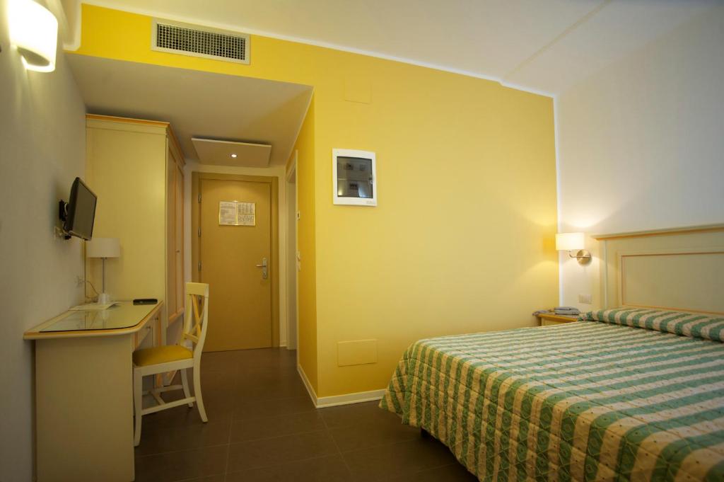 une chambre d'hôtel avec un lit et un bureau dans l'établissement Hotel Stella Marina, à San Vincenzo