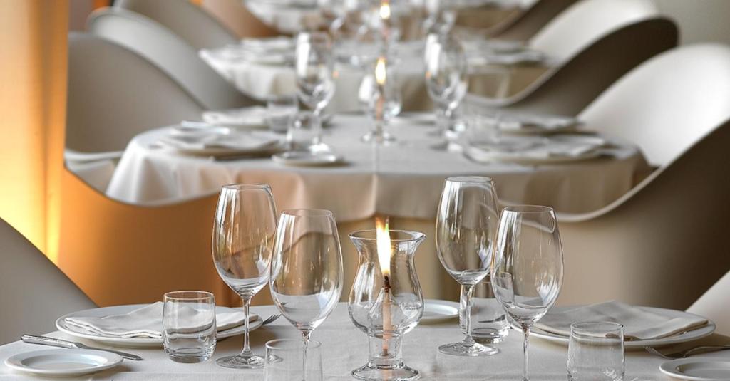 une table avec des verres et des assiettes et une table avec une table avec une table à table dans l'établissement Altamarea Residence & Family Hotel, à Cervia