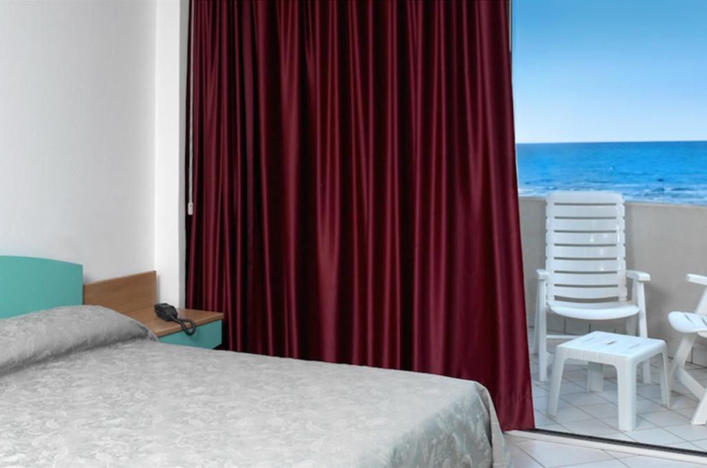 une chambre avec un lit et une vue sur l'océan dans l'établissement Altamarea Residence & Family Hotel, à Cervia