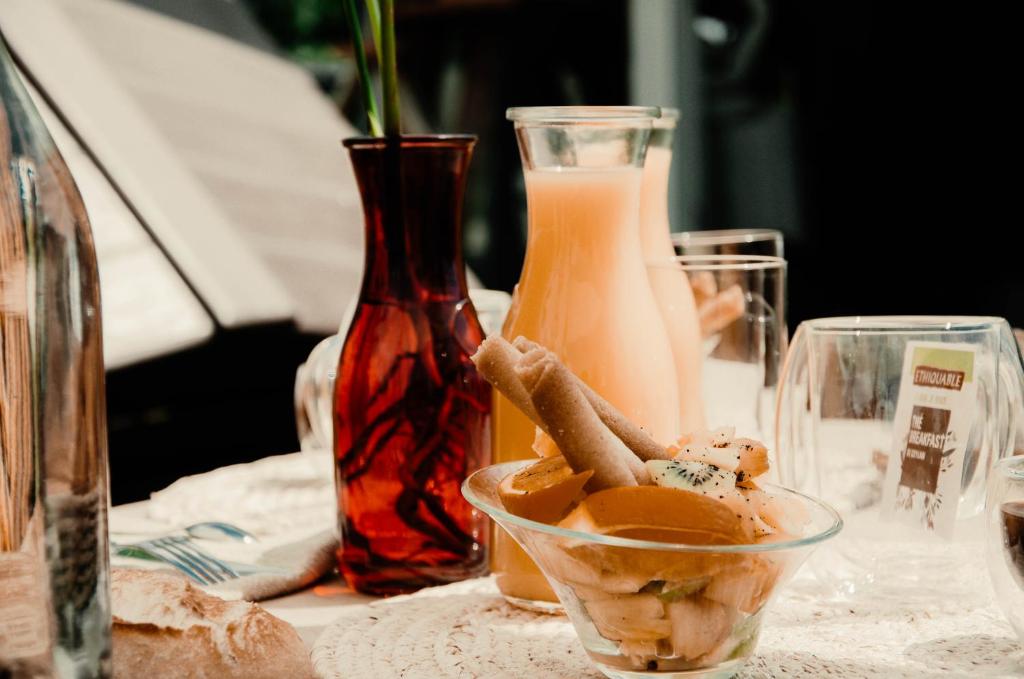 une table avec un bol de nourriture et deux vases dans l'établissement Péniche La Messagère, à Villeneuve-lès-Béziers