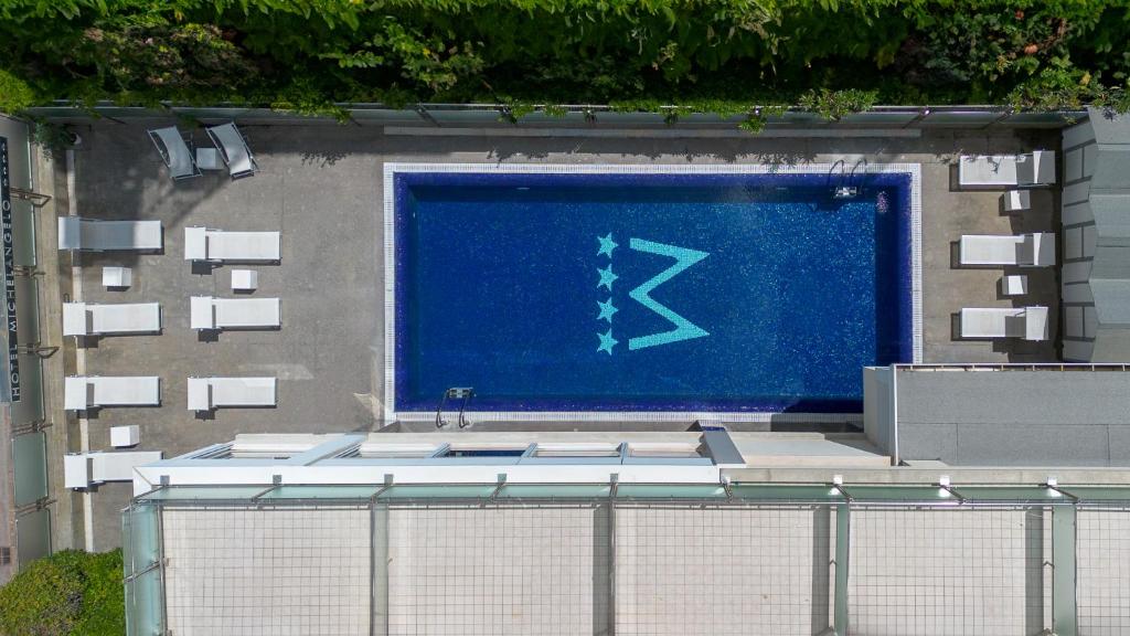 un panneau bleu sur le côté d'un bâtiment dans l'établissement Hotel Michelangelo, à Riccione