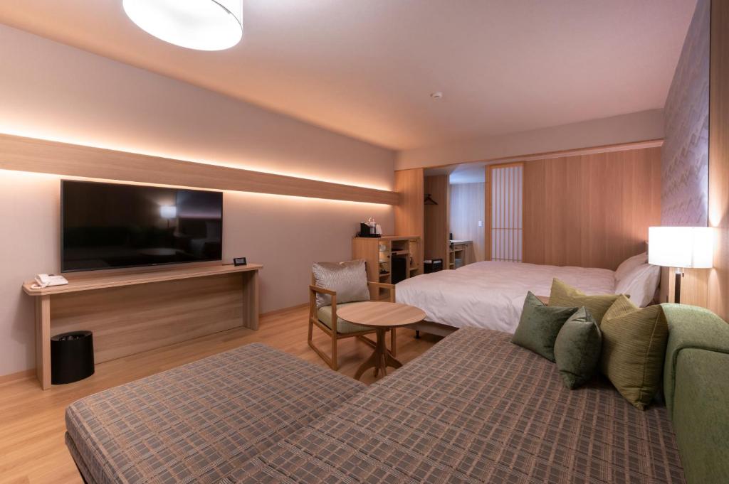 une chambre d'hôtel avec un lit et une télévision à écran plat dans l'établissement Hotel Tokinoza, à Kihokucho
