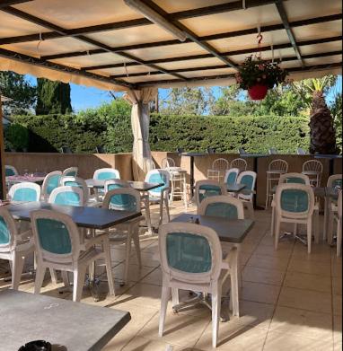 un groupe de tables et de chaises sous un toit dans l'établissement MOBIL HOME GLAMPING CONFORT D'UN HOTEL SANS LES CONTRAINTES PISCINE PROMOTION SEPTEMBRE 3 CHAMBRES - 2 SdB -climatisé - 300m de la mer - piscine - parking -, à Hyères