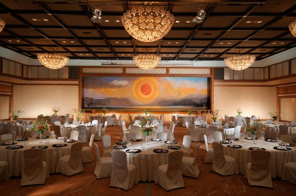 une salle de banquet avec des tables et des chaises blanches et un paravent dans l'établissement Suimeikan, à Gero 37 autres photos
