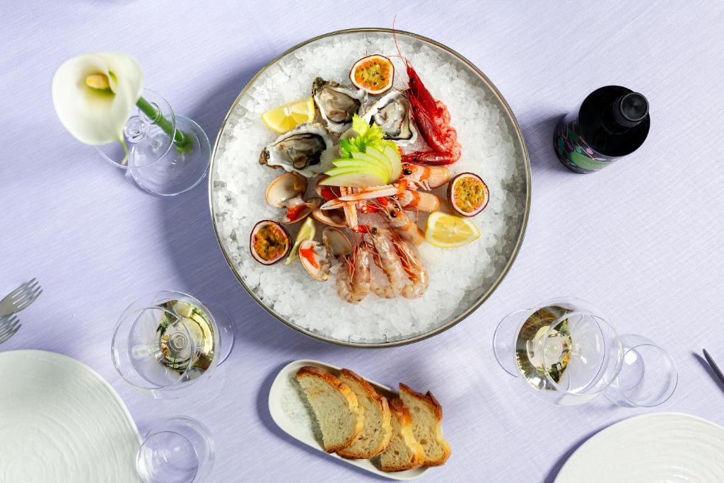une table blanche avec une plaque de nourriture dans l'établissement Valentino SPA Resort, à Grottammare