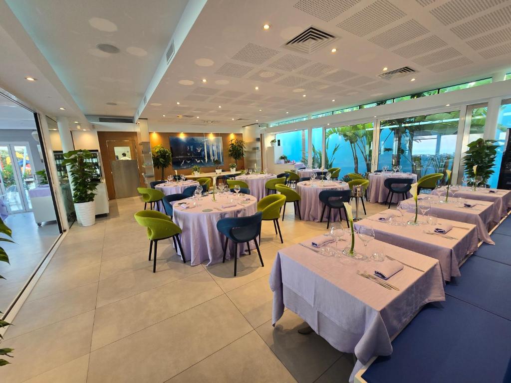 une salle à manger avec tables et chaises et nappes violettes dans l'établissement Valentino SPA Resort, à Grottammare