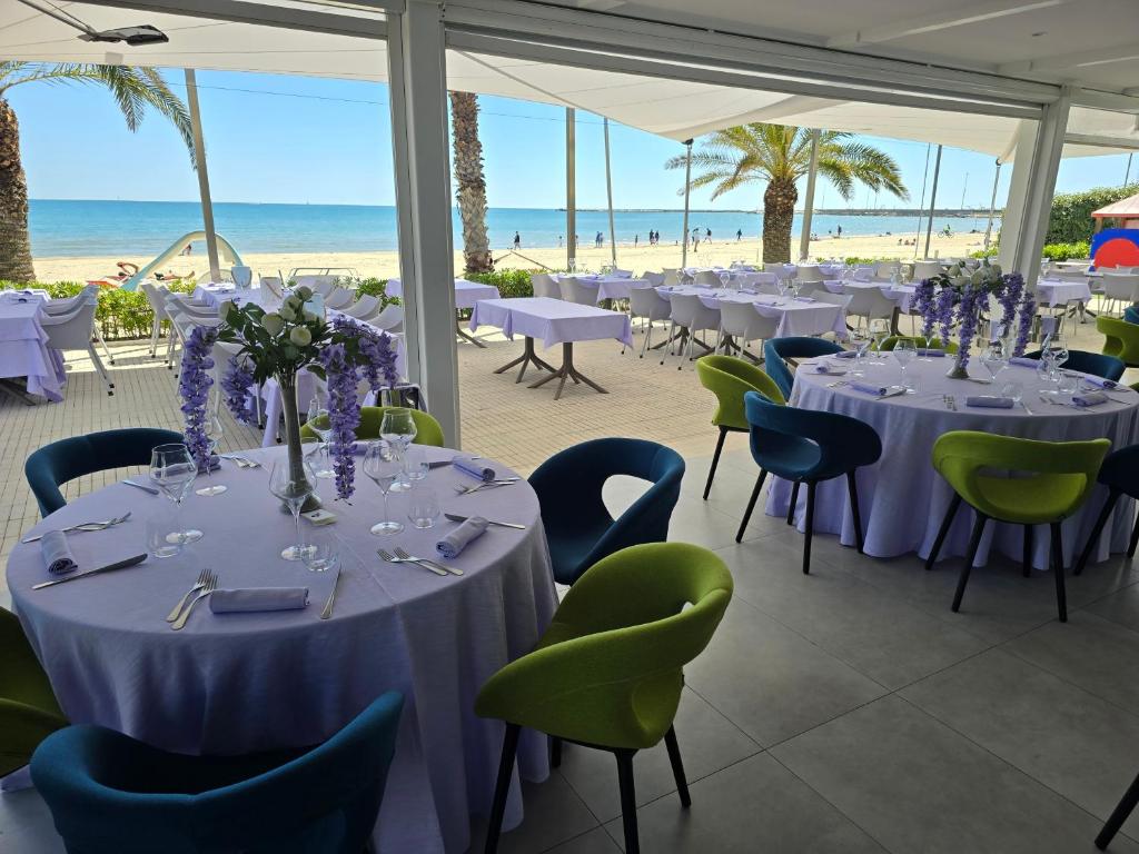 une salle de banquet avec tables et chaises et la plage dans l'établissement Valentino SPA Resort, à Grottammare 121 autres photos