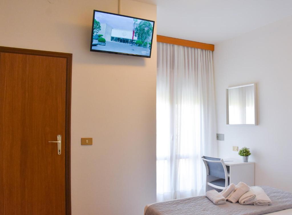 une chambre d'hôtel avec une télévision murale dans l'établissement Hotel Umberto, à Lido di Jesolo