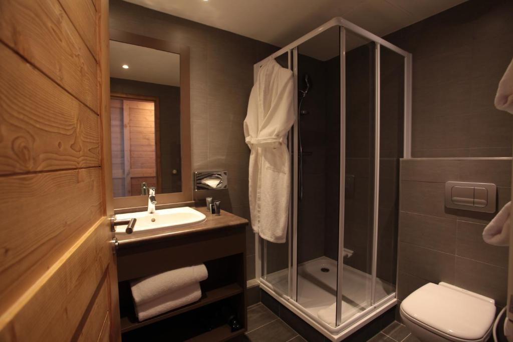 une salle de bain avec une douche, un lavabo et des toilettes dans l'établissement Le Chalet du Mont Vallon Spa Resort, aux Menuires