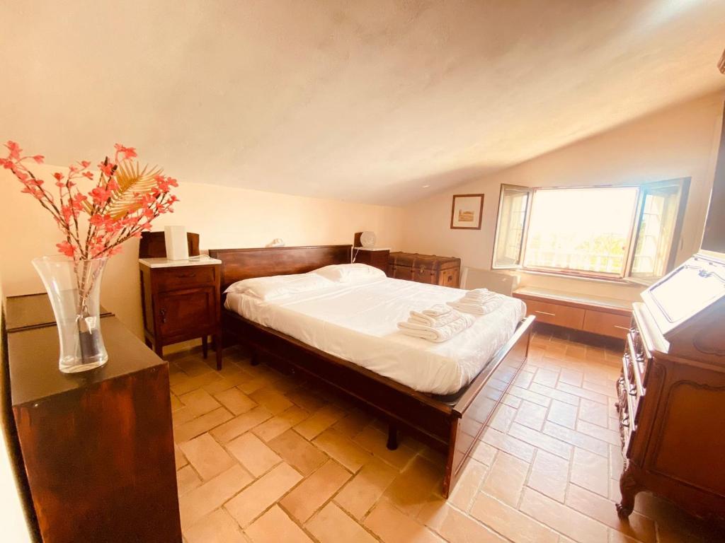 - une chambre avec un lit et un vase de fleurs dans l'établissement Splendida villa con piscina, à Vignanello
