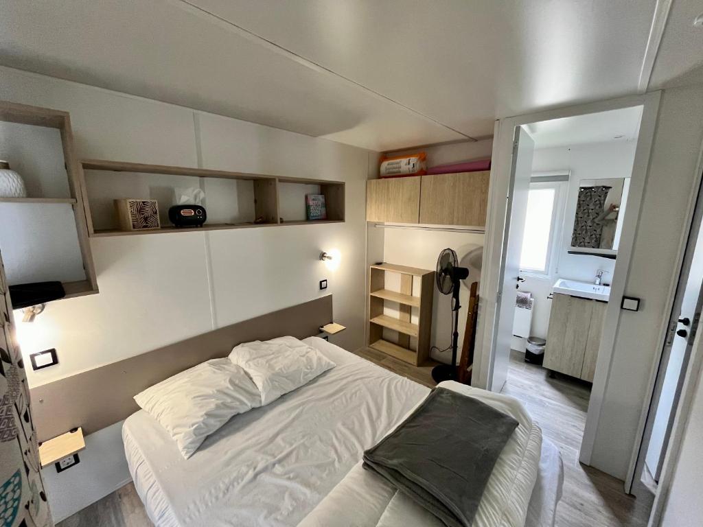 - une petite chambre avec un lit et une télévision dans l'établissement Mobil-home 5 pers climatisé - Plage et forêt - Camping Les Oyats Seignosse, à Seignosse