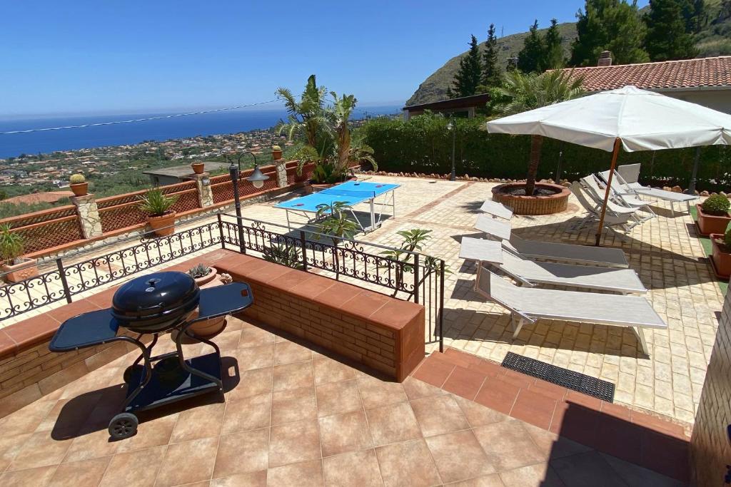 une terrasse avec un barbecue, des chaises et une piscine dans l'établissement Villa Belvedere di Altavilla with Pool and Near The Sea, à Altavilla Milicia