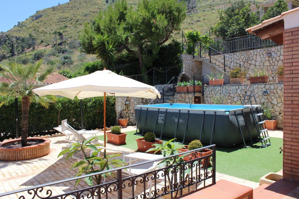 un patio avec un parasol et une piscine dans l'établissement Villa Belvedere di Altavilla with Pool and Near The Sea, à Altavilla Milicia