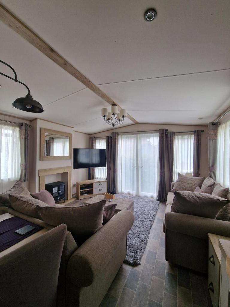 un salon avec des canapés et une télévision à écran plat dans l'établissement Premium Mobilhome Grimaud, à Grimaud 13 autres photos