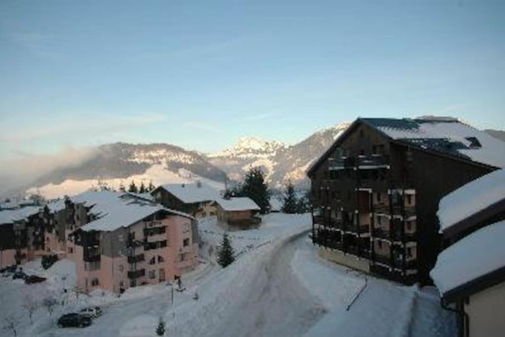 une rue enneigée dans une ville avec des bâtiments dans l'établissement appartement montagne la vallée verte cœur station Hirmentaz, à Bellevaux
