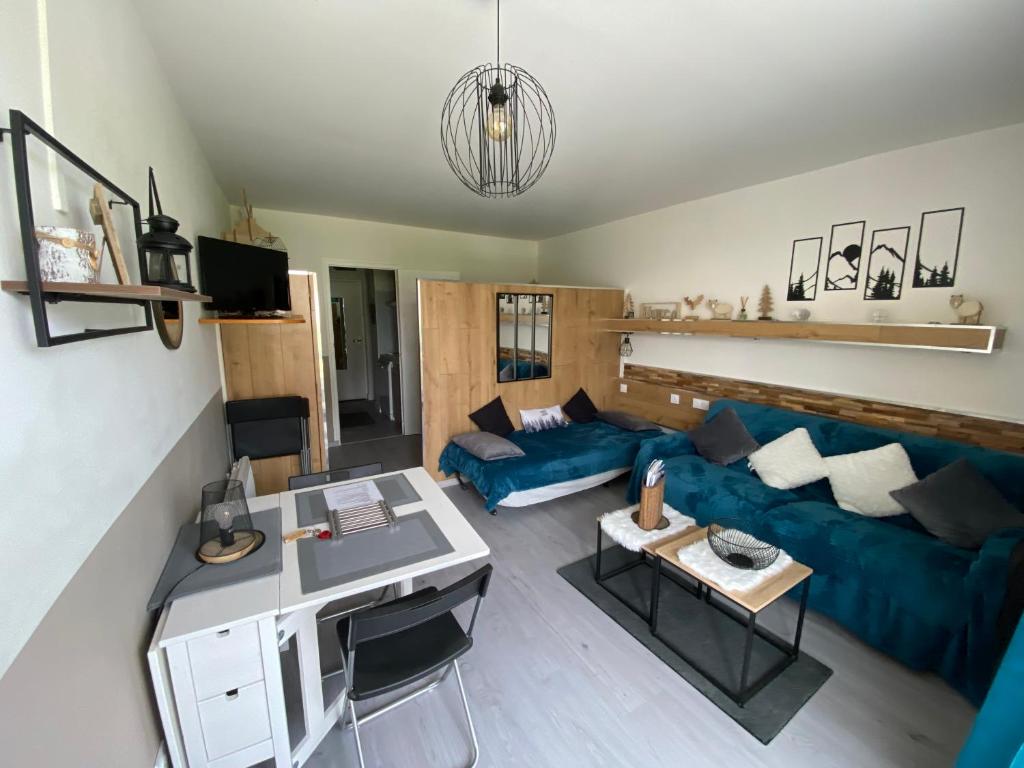 un salon avec un canapé bleu et une table dans l'établissement STUDIO AUX PIEDS DES PISTES, à Saint-Étienne-en-Dévoluy