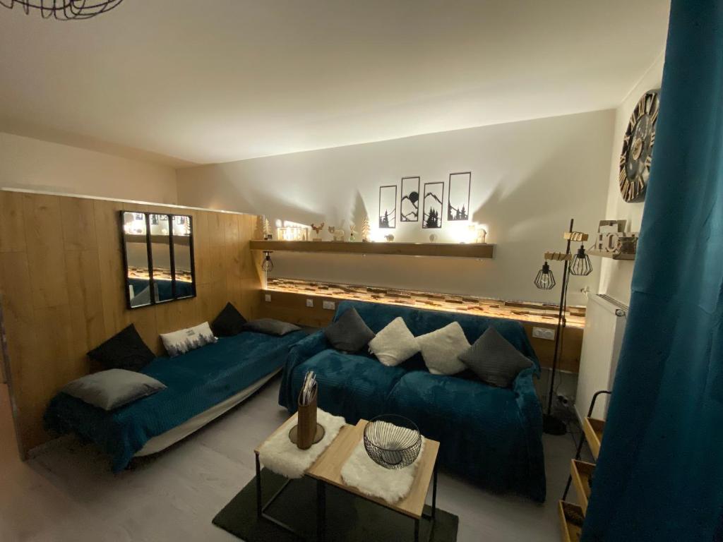 un salon avec un canapé bleu et une table dans l'établissement STUDIO AUX PIEDS DES PISTES, à Saint-Étienne-en-Dévoluy