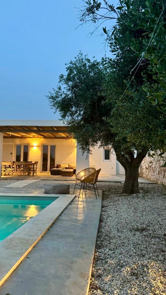 une maison avec un arbre à côté d'une piscine dans l'établissement Villa Pupetta Ostuni 4 bedrooms 4 bathrooms - swimming pool, à Ostuni