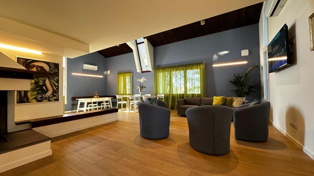 - un salon avec des murs bleus, un canapé et des chaises dans l'établissement Villa Pronti Santarcangelo - Rimini, à Santarcangelo di Romagna