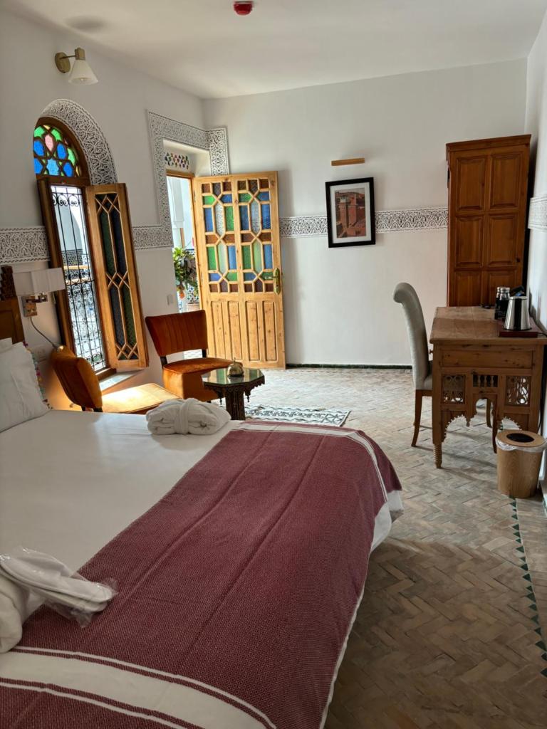 une chambre avec un lit, une table et un bureau dans l'établissement Dar Al Miraaj, à Rabat
