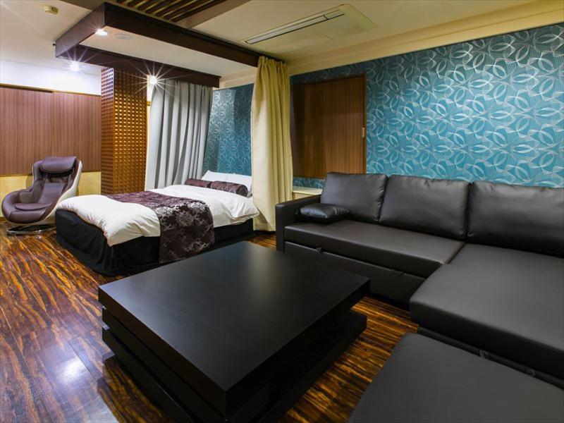 une chambre d'hôtel avec un canapé et un lit dans l'établissement HOTEL C-PLUS - Adult Only, à Gyōda