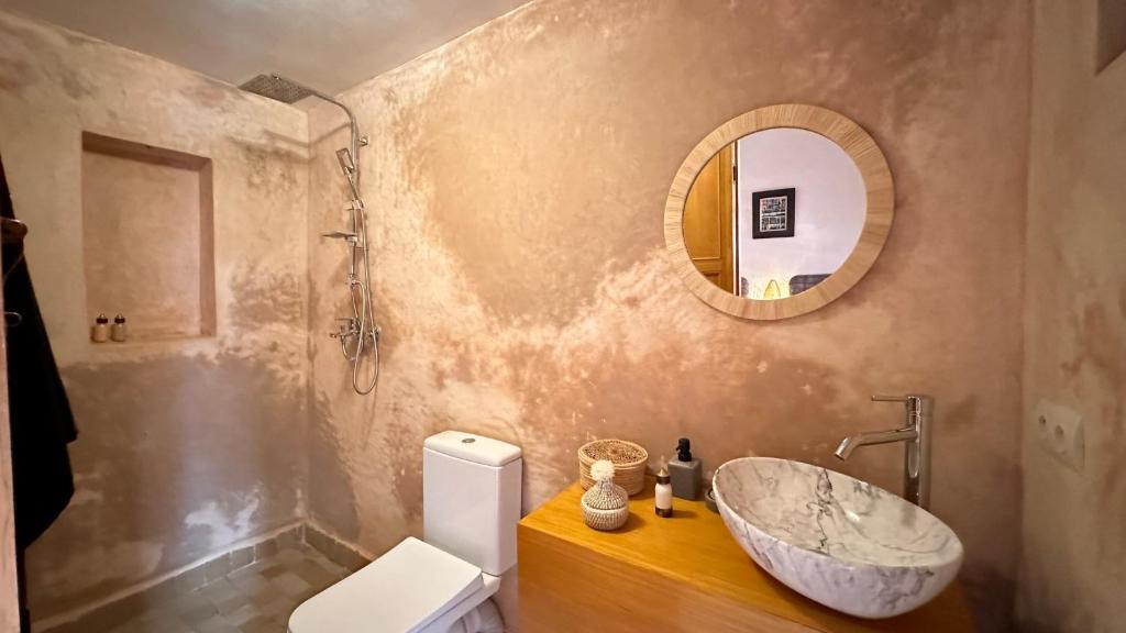 une salle de bain avec un lavabo, des toilettes et un miroir dans l'établissement Alibaba Riad, à Fès
