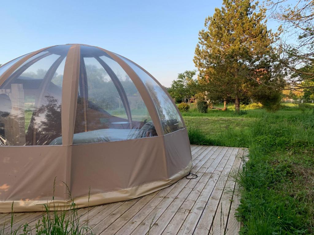 une tente dôme posée sur une terrasse dans un champ dans l'établissement Bulle insolite Wigwam, à Aulnay-sur-Iton