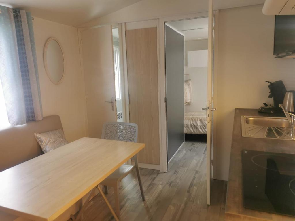 un salon avec une table en bois et une chambre dans l'établissement Soleil Luna, à Herm