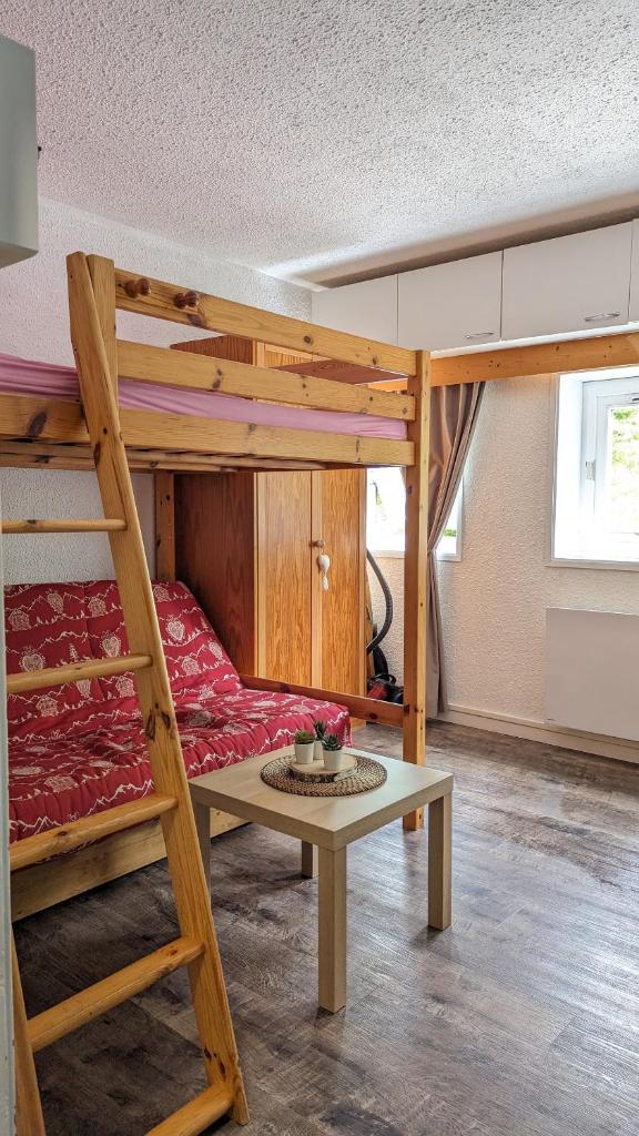 une chambre avec un lit superposé et une table dans l'établissement Studio avec linge de maison fourni et tout équipé aux pieds des pistes, à Villard-de-Lans