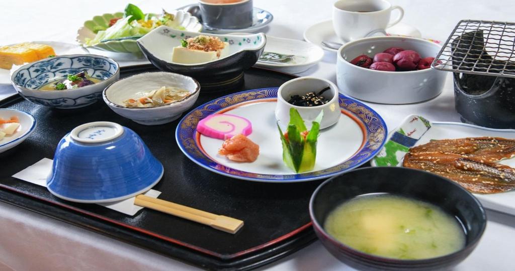 une table recouverte de bols et de assiettes de nourriture dans l'établissement Komatsuya Nagisakan, à Kami Amakusa
