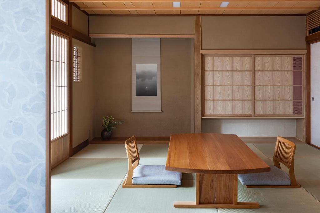 une salle à manger avec une table et des chaises en bois dans l'établissement Mikuniya, à Toyooka