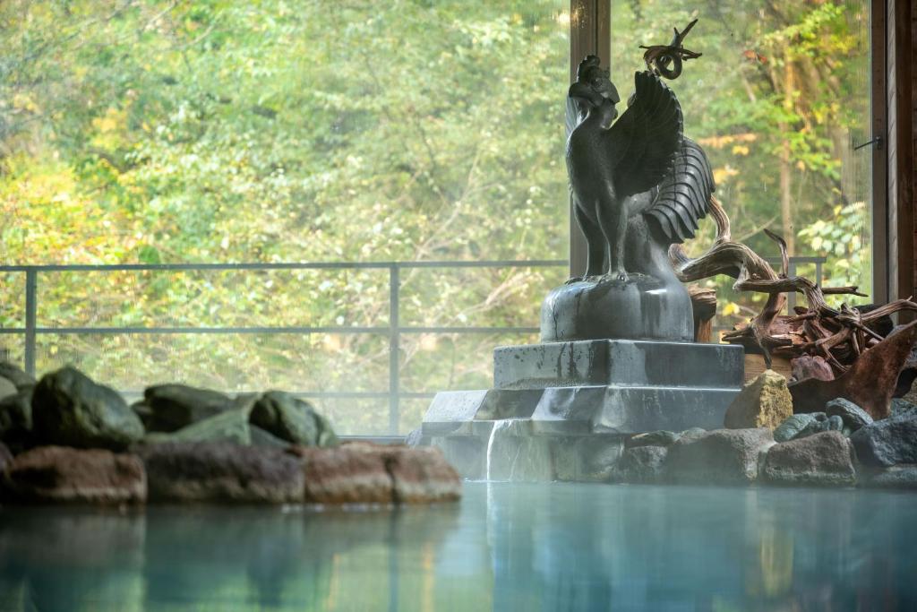 une statue d'un oiseau assis au-dessus d'une fontaine dans l'établissement Yumoto Kissho, à Osaki 111 autres photos