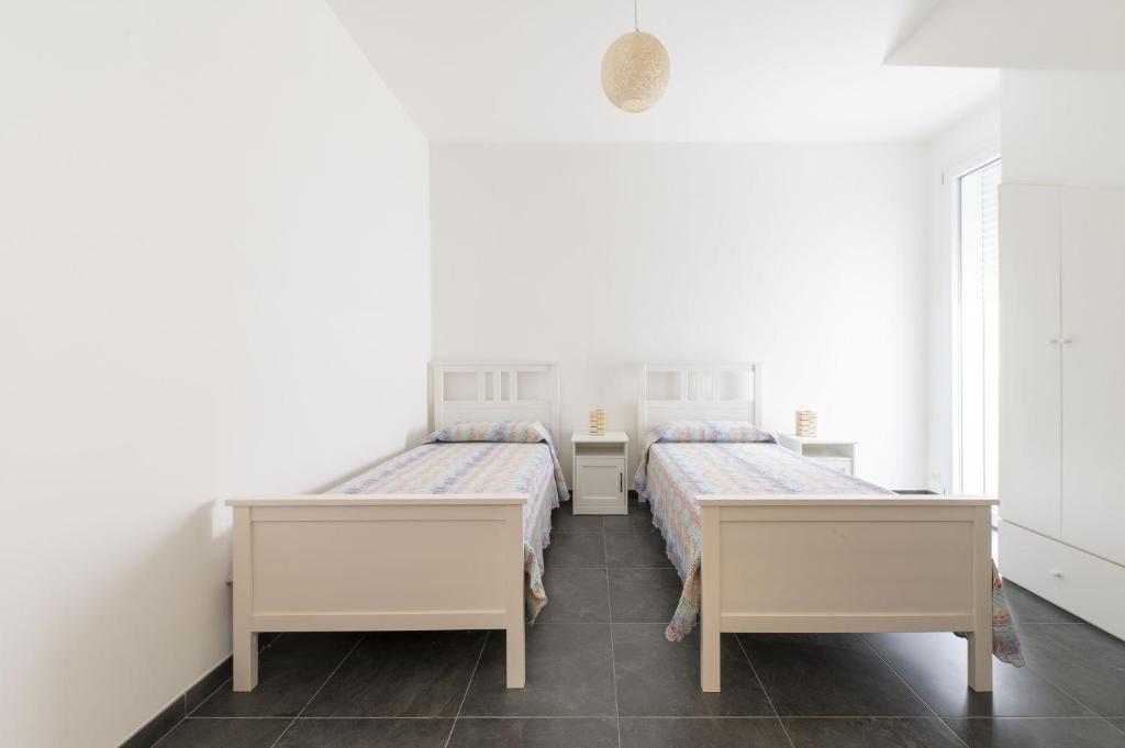 deux lits dans une chambre aux murs blancs dans l'établissement Villa Venza , Salento, à Otrante