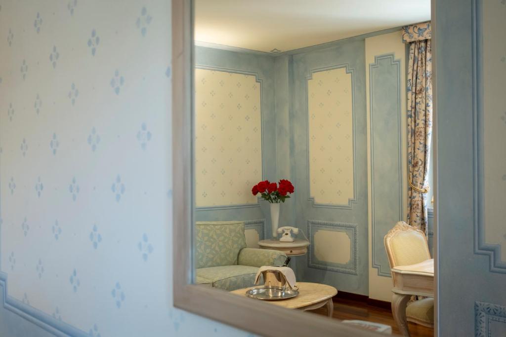 un miroir dans une pièce avec une chaise et un canapé dans l'établissement Suite Hotel Nettuno, à Sestri Levante