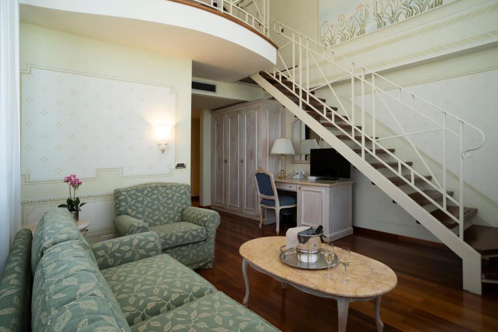 un salon avec un canapé et un escalier dans l'établissement Suite Hotel Nettuno, à Sestri Levante