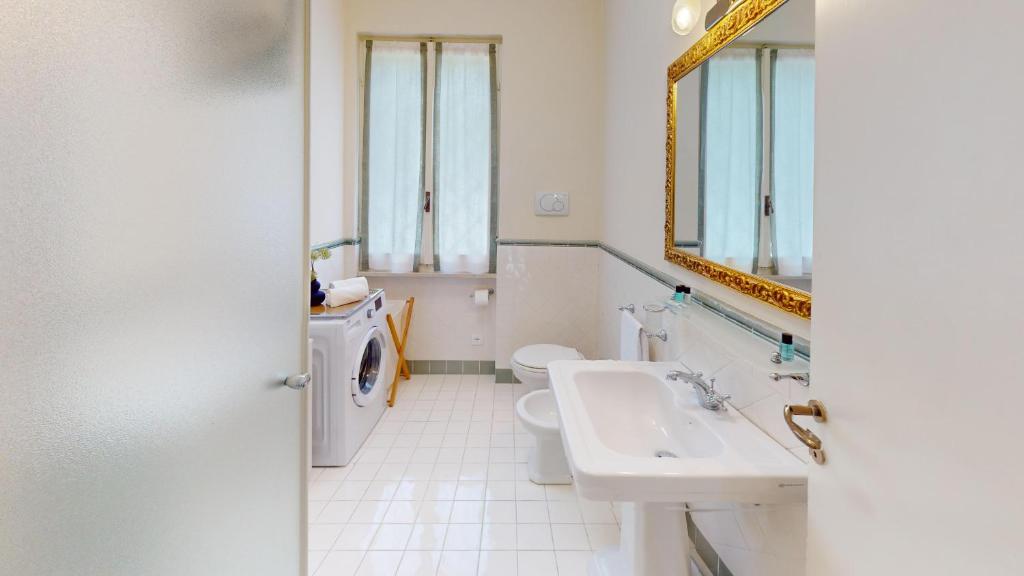 une salle de bain avec un lavabo, des toilettes et un miroir dans l'établissement Villa Oleandri-BGL, à Salò
