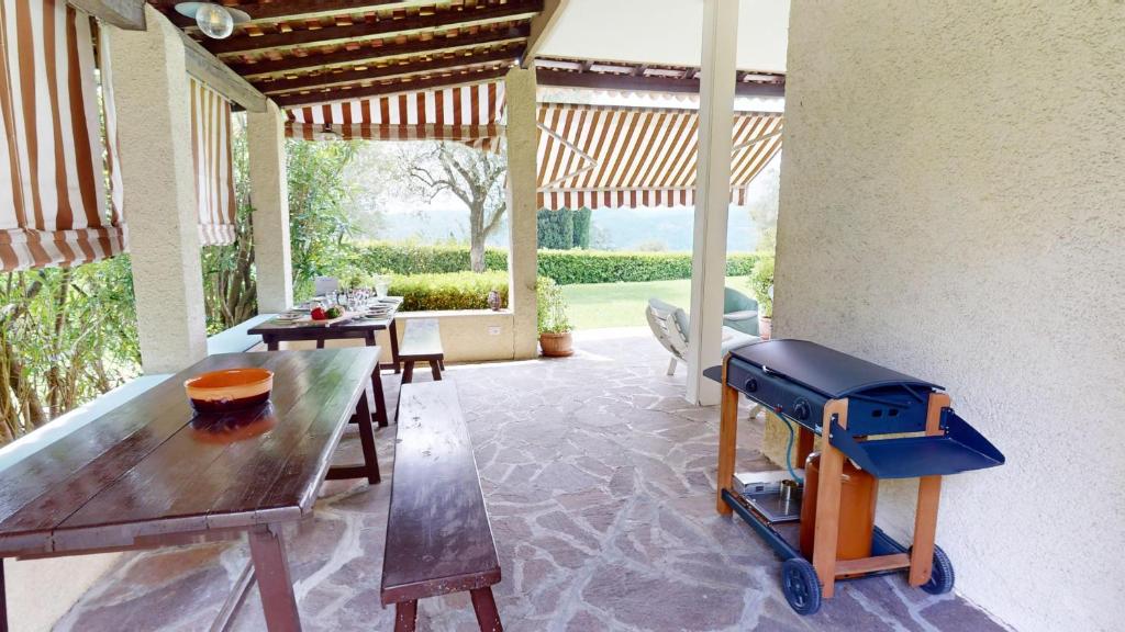 d'une terrasse avec une table en bois et un grill. dans l'établissement Villa Oleandri-BGL, à Salò