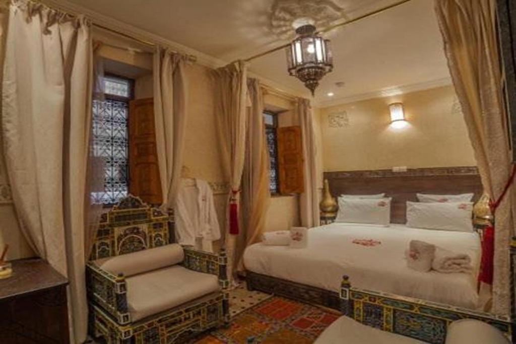 - une chambre avec 2 lits et une chaise dans l'établissement Riad Ikalimo 1, à Marrakech