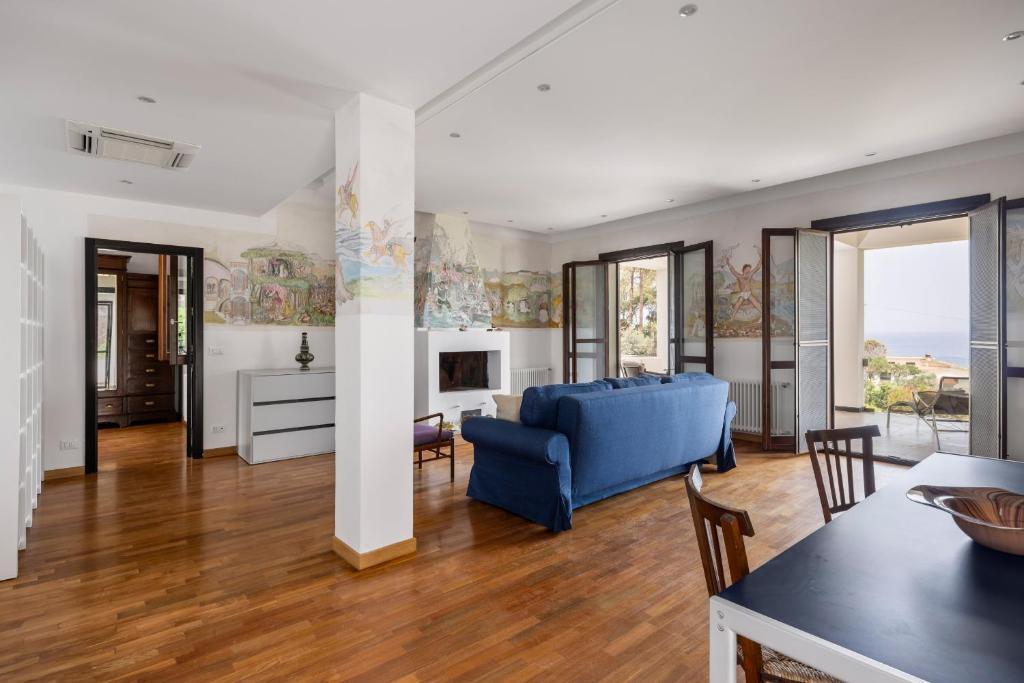 un salon avec un canapé bleu et une table dans l'établissement Villa Angelica by Wonderful Italy, à Castellammare del Golfo