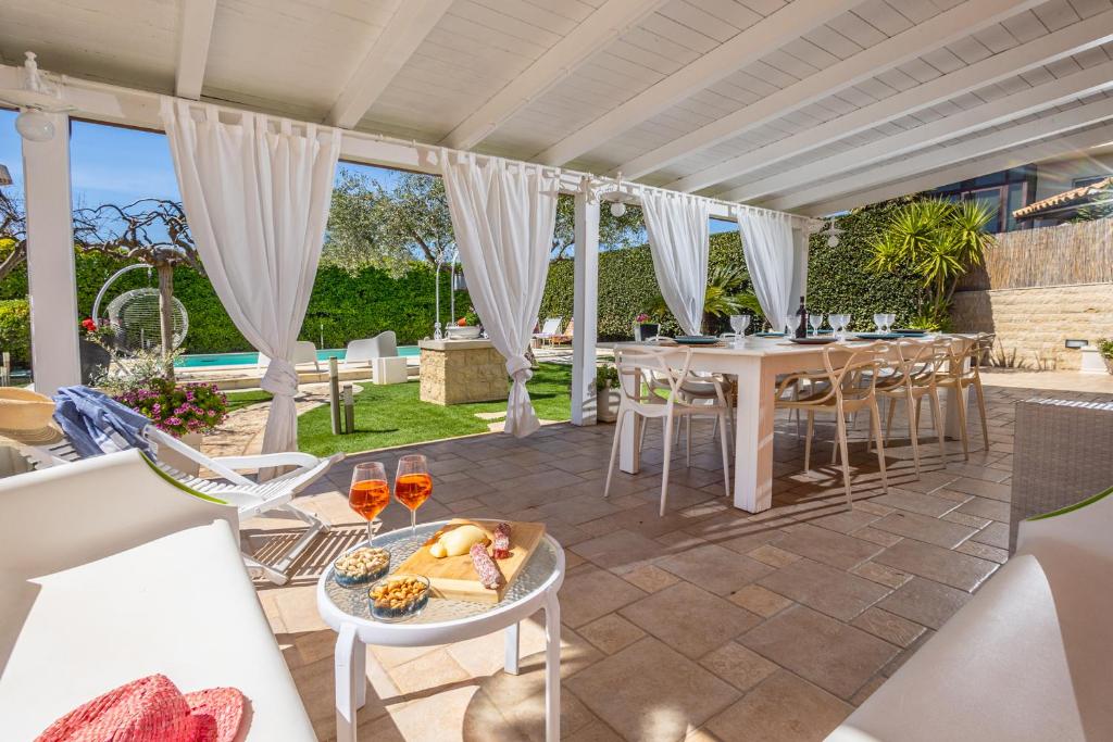 un patio extérieur avec une table et des chaises dans l'établissement Luxury villa at Pozzallo at 390 meters about from the beach with private swimming pool, à Pozzallo
