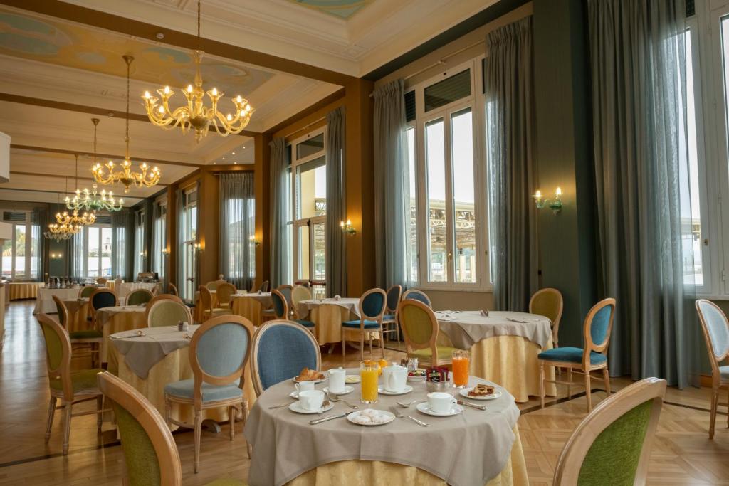 une salle à manger avec tables, chaises et fenêtres dans l'établissement Suite Hotel Nettuno, à Sestri Levante