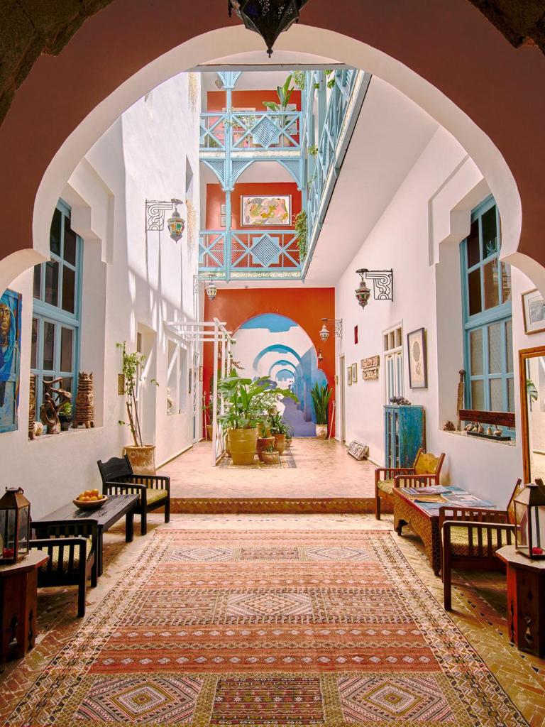 une arche dans un bâtiment avec des tables et des bancs dans l'établissement Ryad Watier & SPA, à Essaouira