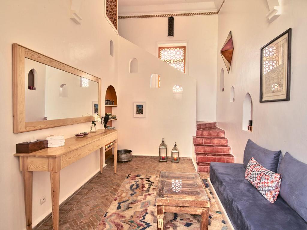 un salon avec un canapé bleu et un miroir dans l'établissement Ryad Watier & SPA, à Essaouira